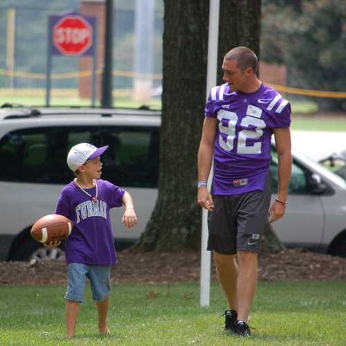 football player walking with child